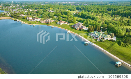 Lakeside mansion properties aerial with boat docks and forested skyline Lakeside mansion properties aerial with boat docks and forested skyline 105569808