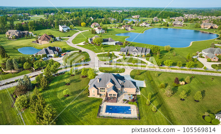 Aerial pond side properties rich expensive neighborhood fresh cut lawns and pool in backyard Aerial pond side properties rich expensive neighborhood fresh cut lawns and pool in backyard 105569814