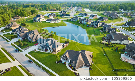 Large pond in rich expensive neighborhood aerial with mini mansions, high-end, million-dollar homes 105569890