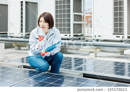 A female worker who performs maintenance inspection of the solar panel 105570023