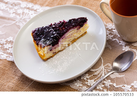 Slice of classic creamy cheesecake with cranberries sauce 105570533