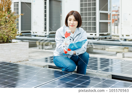 一名女工正在對太陽能電池板進行維護檢查 一名女工正在對太陽能電池板進行維護檢查 105570563