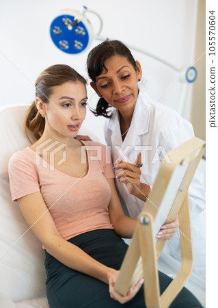 Beautician examining face skin of female patient Beautician examining face skin of female patient 105570604