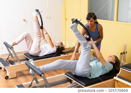 Teens training in pilates lessons led by female trainer Teens training in pilates lessons led by female trainer 105570669