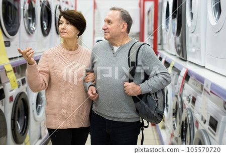 Happy spouses of mature age choose a washing machine Happy spouses of mature age choose a washing machine 105570720