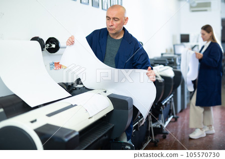 Man working in printing office, using printer Man working in printing office, using printer 105570730