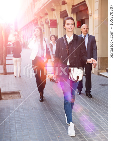 People in formal wear walking down street in city 105570807