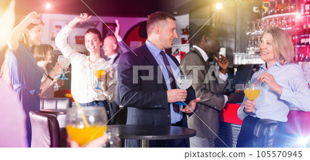 Middle aged woman with male colleague enjoying office party 105570945