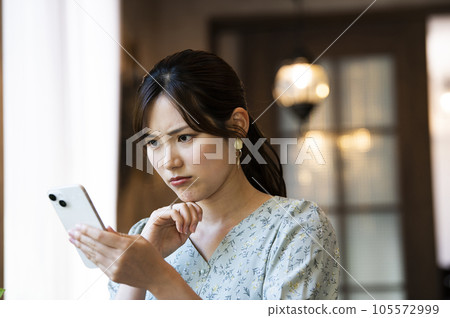 A woman using her smartphone in a cafe A woman using her smartphone in a cafe 105572999