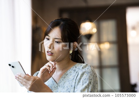 一位女士在咖啡館操作智慧型手機 105573000