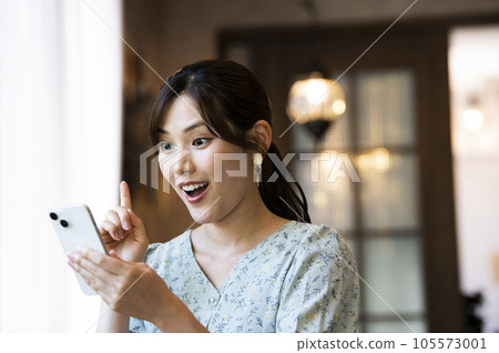 一位女士在咖啡館操作智慧型手機 一位女士在咖啡館操作智慧型手機 105573001