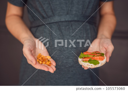 A thoughtful pregnant woman over 40 considering whether to eat fish or opt for omega 3 capsules for a nourishing and healthy pregnancy A thoughtful pregnant woman over 40 considering whether to eat fish or opt for omega 3 capsules for a nourishing and healthy pregnancy 105573060