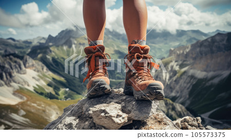woman hiker legs on top of a mountain peak enjoying the view woman hiker legs on top of a mountain peak enjoying the view 105573375
