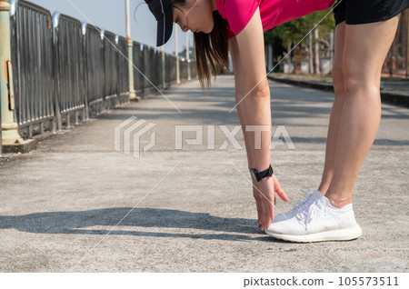 Runner woman doing stretching and warming up her legs before running. Runner woman doing stretching and warming up her legs before running. 105573511
