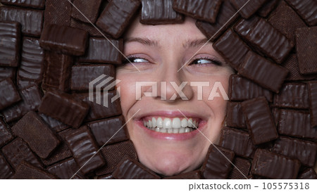 Face of caucasian woman surrounded by chocolates. Face of caucasian woman surrounded by chocolates. 105575318