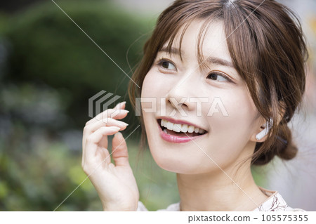 城市裡戴著無線耳機的年輕女子 105575355