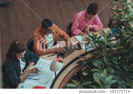 Group of coworkers working together and talking at modern office. Workplace and cooperation concept 105575714