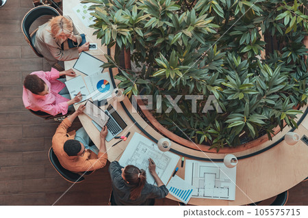 Top view of group of coworkers working together and talking at modern office. Cooperation concept 105575715