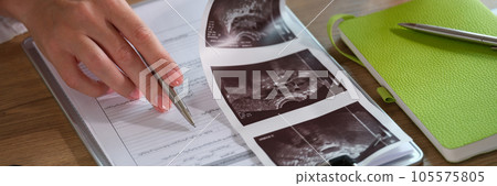 Female doctor analyzes results of patient's medical examination at her desk in clinic. Female doctor analyzes results of patient's medical examination at her desk in clinic. 105575805