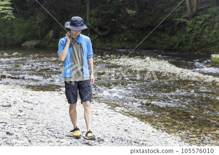 Outdoors young man walking along the river 105576010