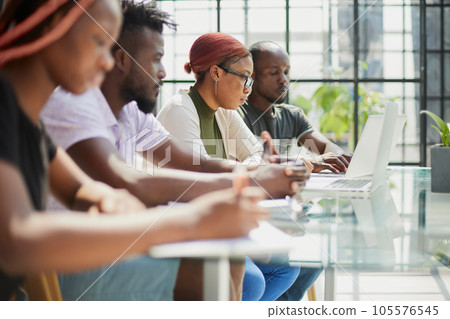 Employees working at computer together, discussing content. Employees working at computer together, discussing content. 105576545