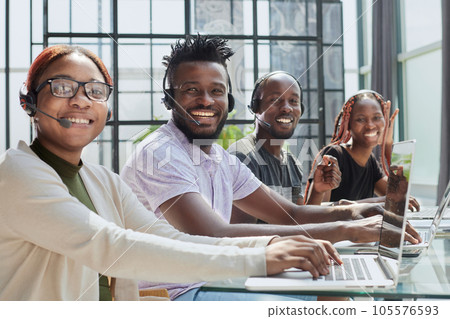 young operators sitting at the workplace posing for the camera 105576593