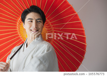 A man in a kimono, a Japanese umbrella 105576773