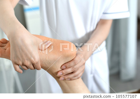 Therapist doing shiatsu massage on the soles of the feet 105577107