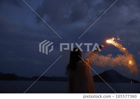 A Japanese woman in her thirties who enjoys handheld fireworks in the summer sea A Japanese woman in her thirties who enjoys handheld fireworks in the summer sea 105577360