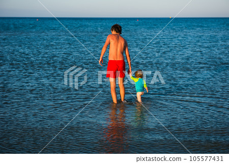 Father and daughter playing together in the sea water 105577431