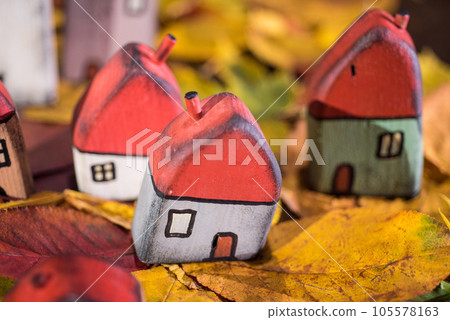 Painted toy houses on autumn leaves 105578163