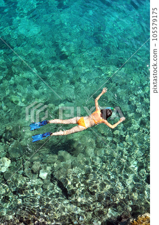 Above view of woman snorkeling in the sea 105579175