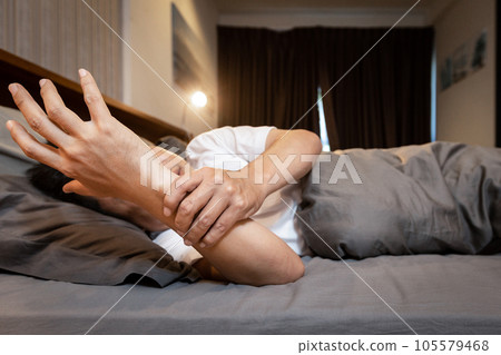 Sick asian middle-aged man with shaking of Parkinson's disease,symptom of resting tremor,stressed male patient holding his hand to control hands tremor while lying in bed,illness,health problems Sick asian middle-aged man with shaking of Parkinson's disease,symptom of resting tremor,stressed male patient holding his hand to control hands tremor while lying in bed,illness,health problems 105579468
