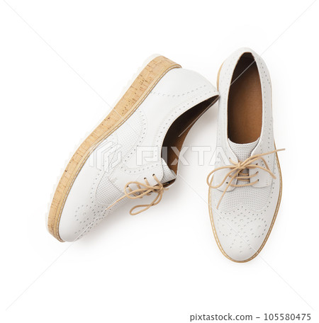 Casual white leather shoes with white laces and cork soles on a white background Casual white leather shoes with white laces and cork soles on a white background 105580475