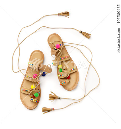 Beach women's leather lace-up sandals. A new pair of shoes on a white background 105580485
