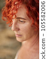Portrait middle age woman with red curly hair looking at sea. Summer holiday rest 105582006