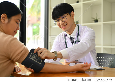 Doctor giving recommendations and measuring blood pressure female patient. Medical and health care concept. 105582676