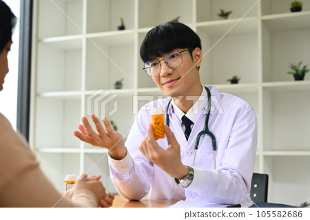 Asian male doctor explaining medicine dosage to patient. Medicine, healthcare and people concept. Asian male doctor explaining medicine dosage to patient. Medicine, healthcare and people concept. 105582686