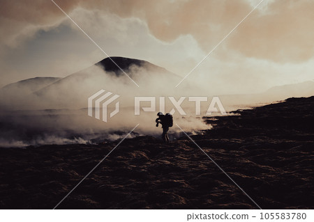 A photographer takes a photo of flowing lava and burning moss under the Icelandic volcano. A photographer takes a photo of flowing lava and burning moss under the Icelandic volcano. 105583780