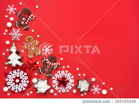 Christmas gingerbread with snowflakes on a red background. Christmas or New Year greeting card. Christmas gingerbread with snowflakes on a red background. Christmas or New Year greeting card. 105585039