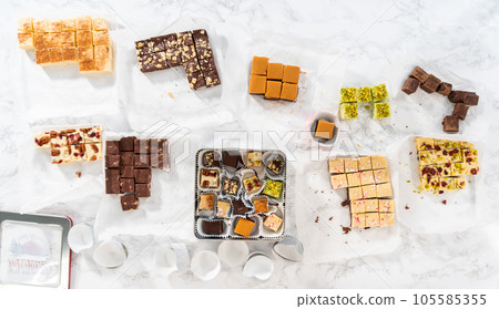 Flat lay. Packaging a homemade variety of fudge for Christmas food gifts into tin boxes. Flat lay. Packaging a homemade variety of fudge for Christmas food gifts into tin boxes. 105585355