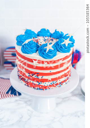 Decorating chocolate cake with white, red, and blue buttercream frosting for July 4th celebration. 105585364