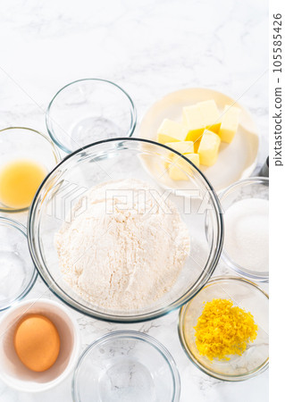 Lemon Cookies with White Chocolate. Measured ingredients in glass mixing bowls to bake lemon cookies with white chocolate. 105585426