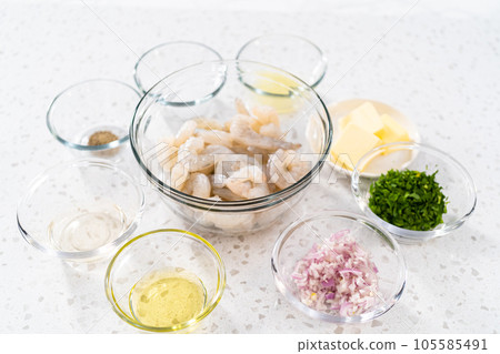 Measured ingredients in glass mixing bowls to make shrimp scampi with linguine pasta. 105585491