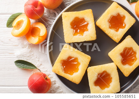Fragrant homemade sliced cake with apricot jam close-up on a plate. Horizontal top view 105585651