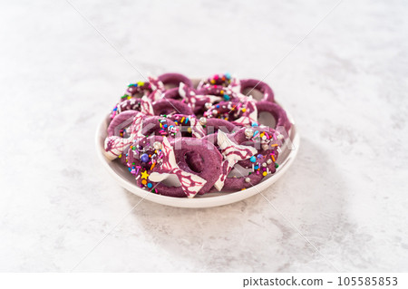 Homemade chocolate-dipped pretzel twists decorated with colorful sprinkles and chocolate mermaid tails on a white plate. Homemade chocolate-dipped pretzel twists decorated with colorful sprinkles and chocolate mermaid tails on a white plate. 105585853