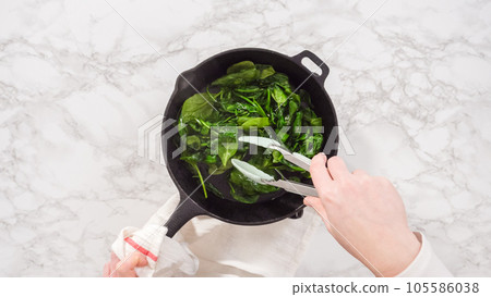 Flat lay. Step by step. Heating cast iron skillet over the stove to prepare spinach and ham frittata. Flat lay. Step by step. Heating cast iron skillet over the stove to prepare spinach and ham frittata. 105586038