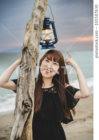 A woman standing on the beach with a view of the sea 105587630