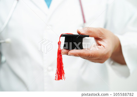 Asian woman doctor holding graduation hat in hospital, Medical education concept. 105588782