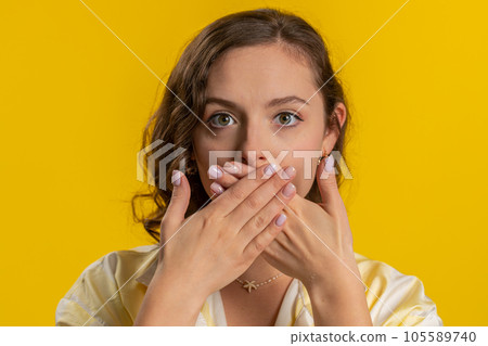 Frightened woman closing mouth with hands refusing to tell terrible secret, unbelievable truth 105589740